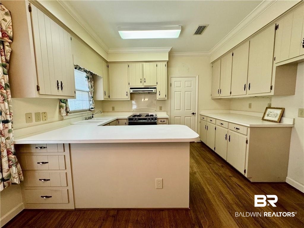 3932 Mcgregor Court Mobile, AL 36608 - Photo 5 of 9 Kitchen featuring gas range oven, kitchen peninsula, and dark hardwood / wood-style floors