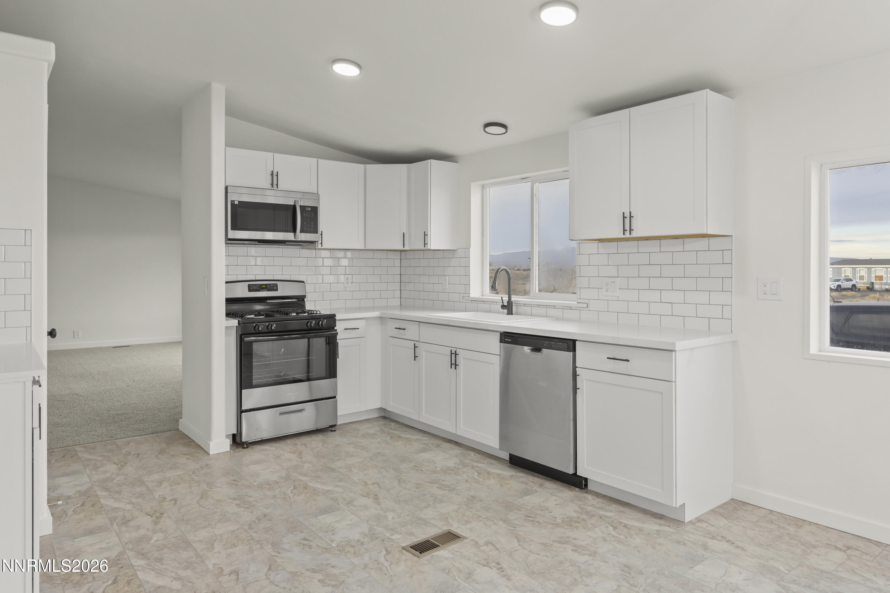 3225 Antelope Street Silver Springs, NV 89429 - Photo 5 of 39 a kitchen with white cabinets stainless steel appliances and sink