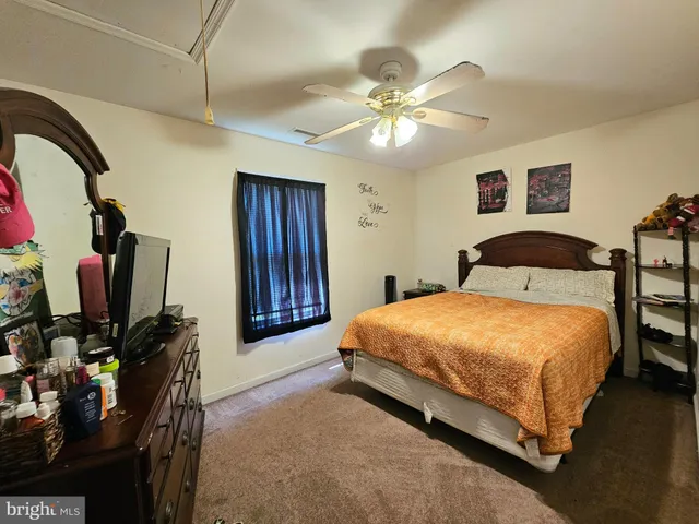 a bedroom with a bed and a flat tv screen on dresser