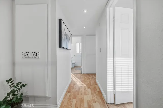 a view of a hallway with wooden floor and staircase