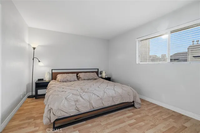 a bedroom with a bed and wooden floor