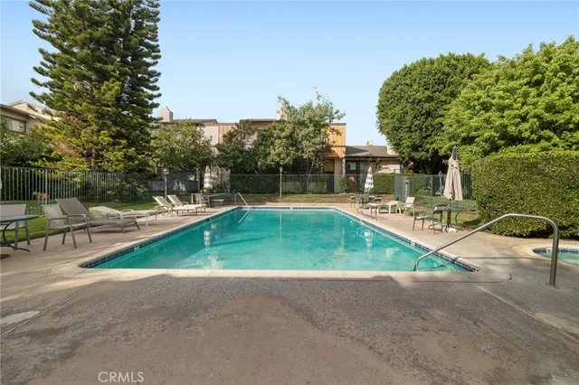 a view of backyard with swimming pool and seating space