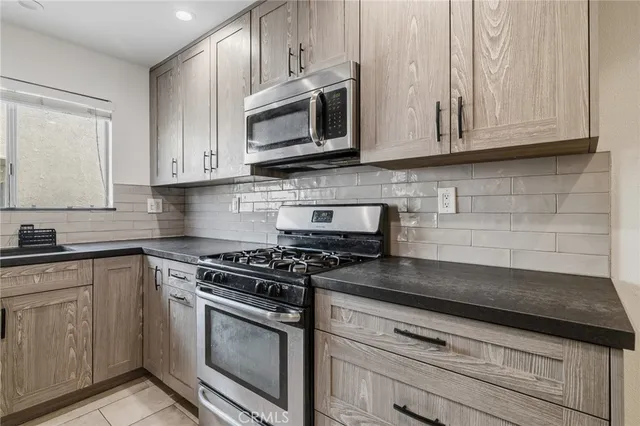 a kitchen with granite countertop white cabinets and stainless steel appliances