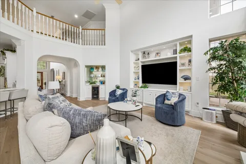 a living room with furniture a flat screen tv and a potted plant