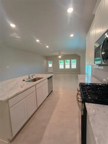 a view of kitchen with kitchen island white cabinets and refrigerator