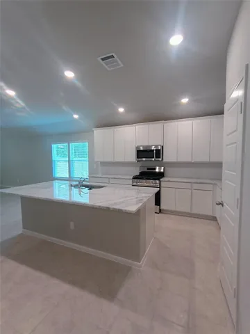a kitchen with sink a stove and cabinets