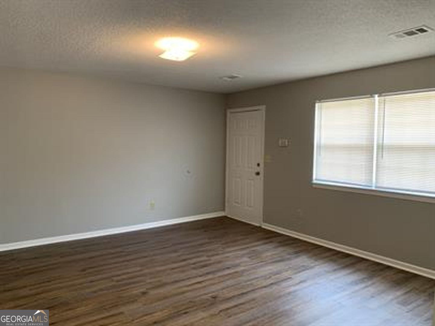 708 Green Street, Unit B Fort Valley, GA 31030 - Photo 4 of 12 a view of wooden floor and windows in a room