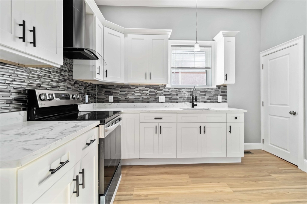 51 Mansfield Street, Unit 51 Everett, MA 02149 - Photo 3 of 19 a kitchen with white cabinets sink and stove