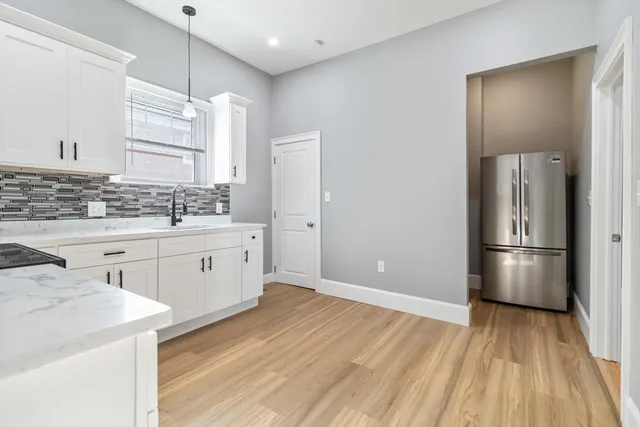 a kitchen with a refrigerator a sink and dishwasher with wooden floor