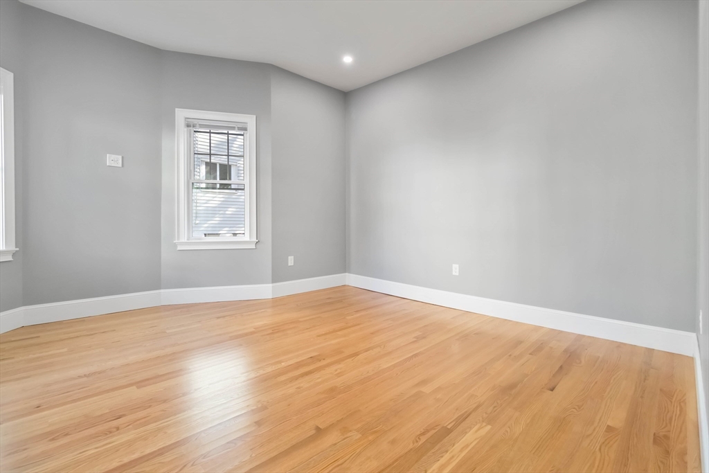 51 Mansfield Street, Unit 51 Everett, MA 02149 - Photo 5 of 19 an empty room with wooden floor and windows