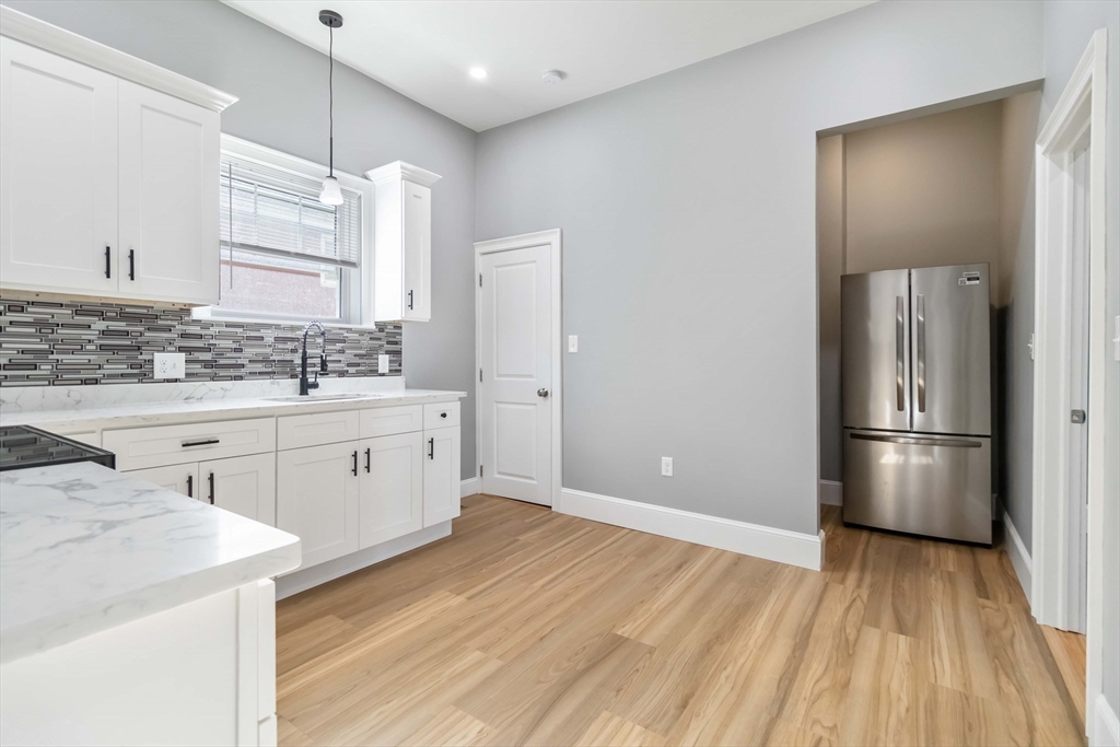 51 Mansfield Street, Unit 51 Everett, MA 02149 - Photo 6 of 19 a kitchen with a sink wooden floor and white cabinets