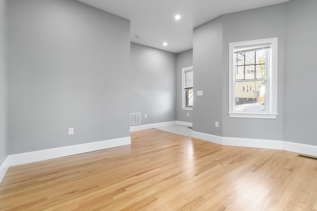 51 Mansfield Street, Unit 51 Everett, MA 02149 - Photo 7 of 19 an empty room with wooden floor and windows