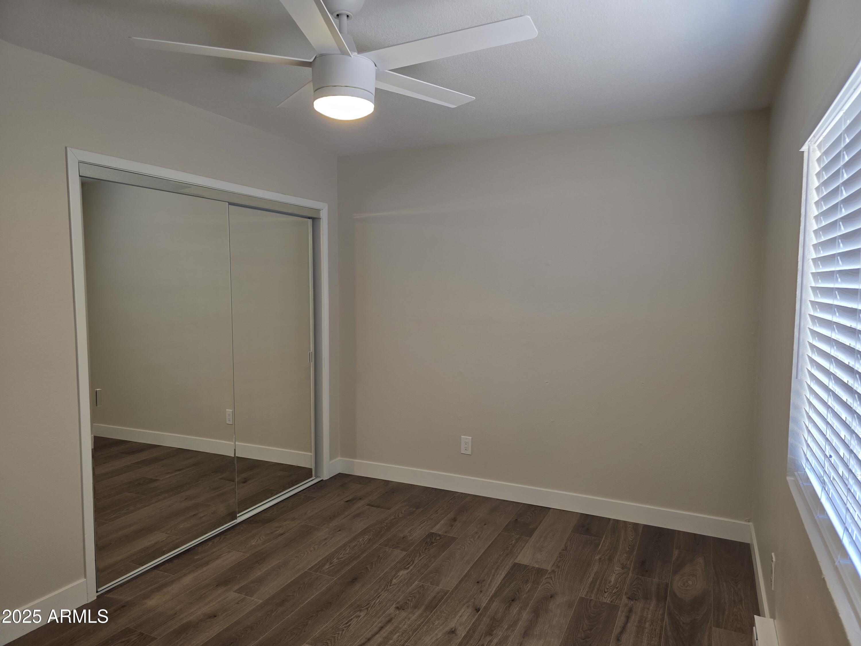 731 Elm Lane Eagar, AZ 85925 - Photo 13 of 26 an empty room with wooden floor fan and windows