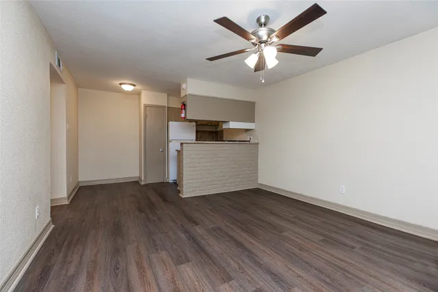 a kitchen with cabinets and wooden floor
