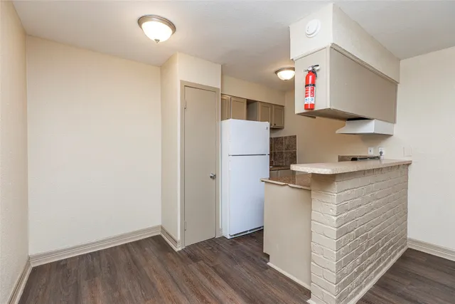a kitchen with a refrigerator and a stove top oven