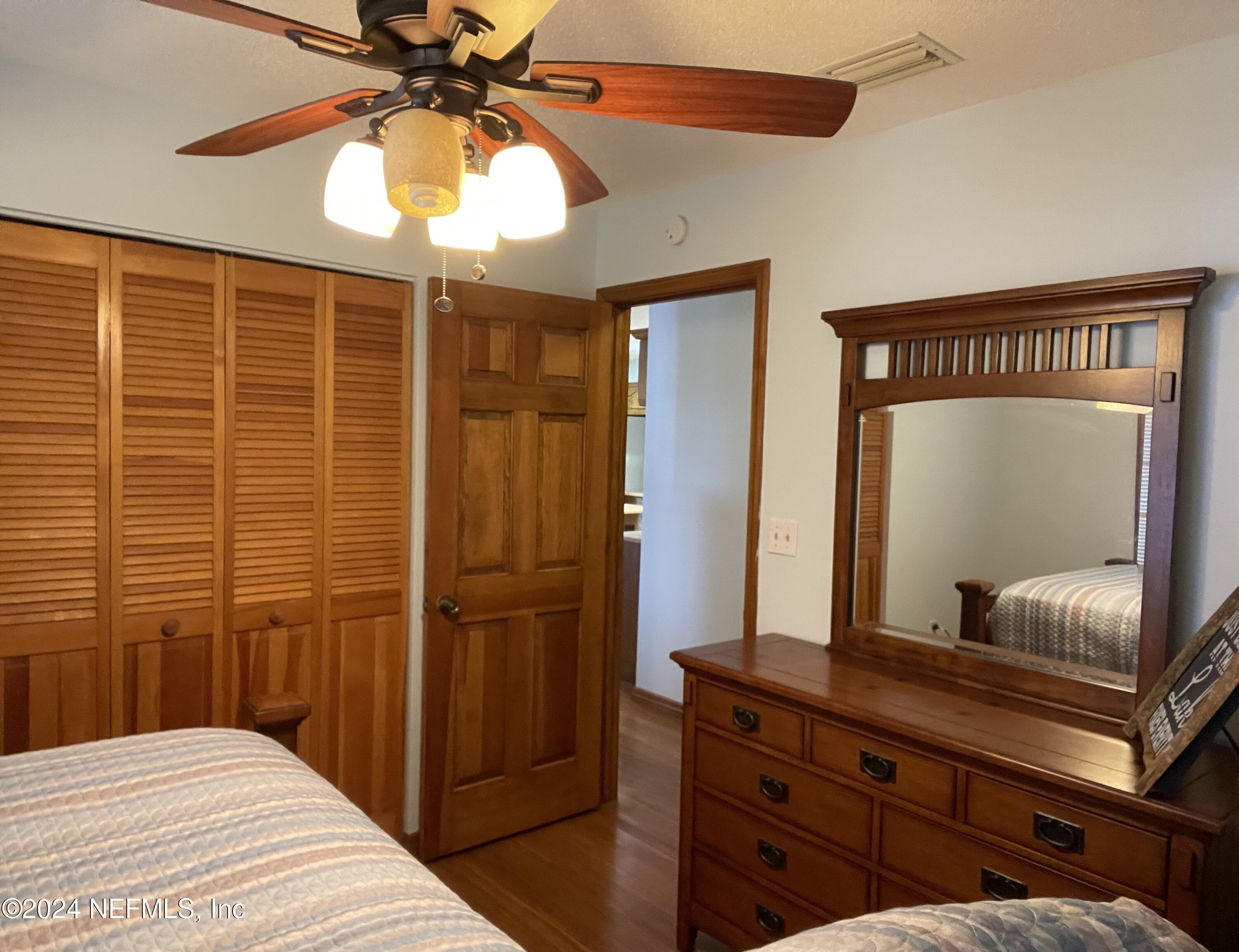 110 North Point Drive Georgetown, FL 32139 - Photo 16 of 28 a bedroom with a large bed and a chandelier