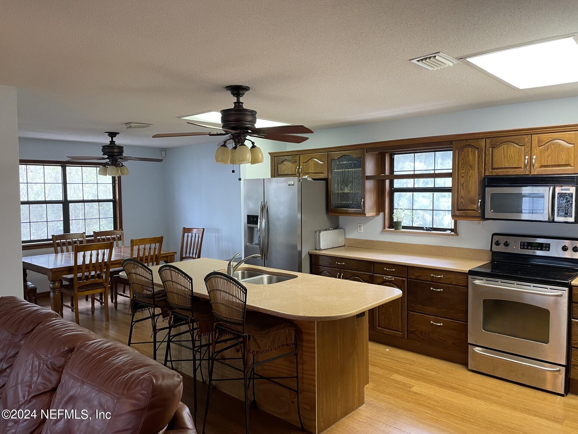 110 North Point Drive Georgetown, FL 32139 - Photo 7 of 28 a kitchen with stainless steel appliances granite countertop a stove a sink a dining table and chairs