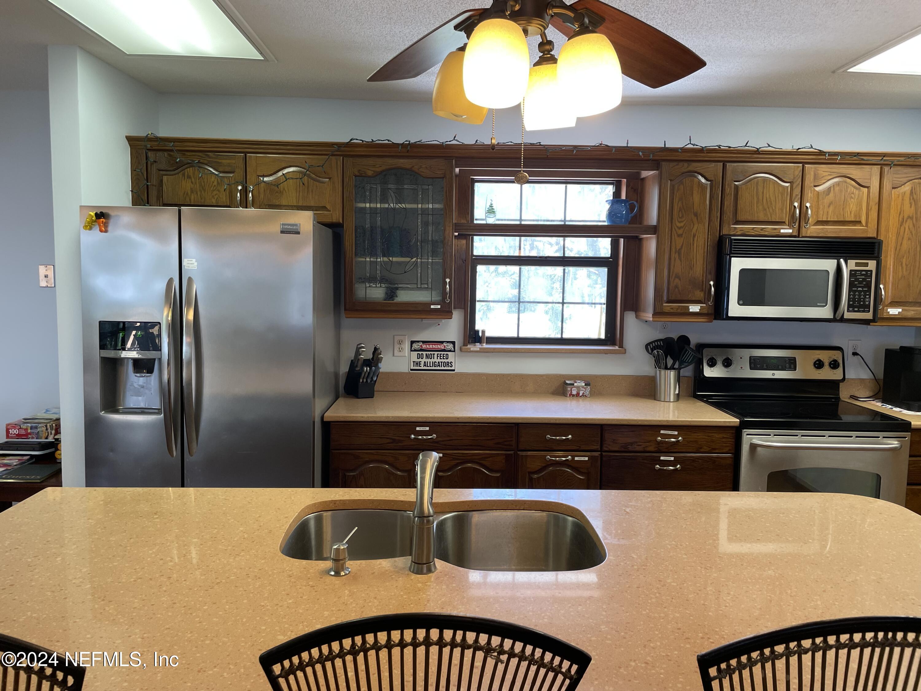 110 North Point Drive Georgetown, FL 32139 - Photo 8 of 28 a kitchen with stainless steel appliances granite countertop a sink a stove and a refrigerator