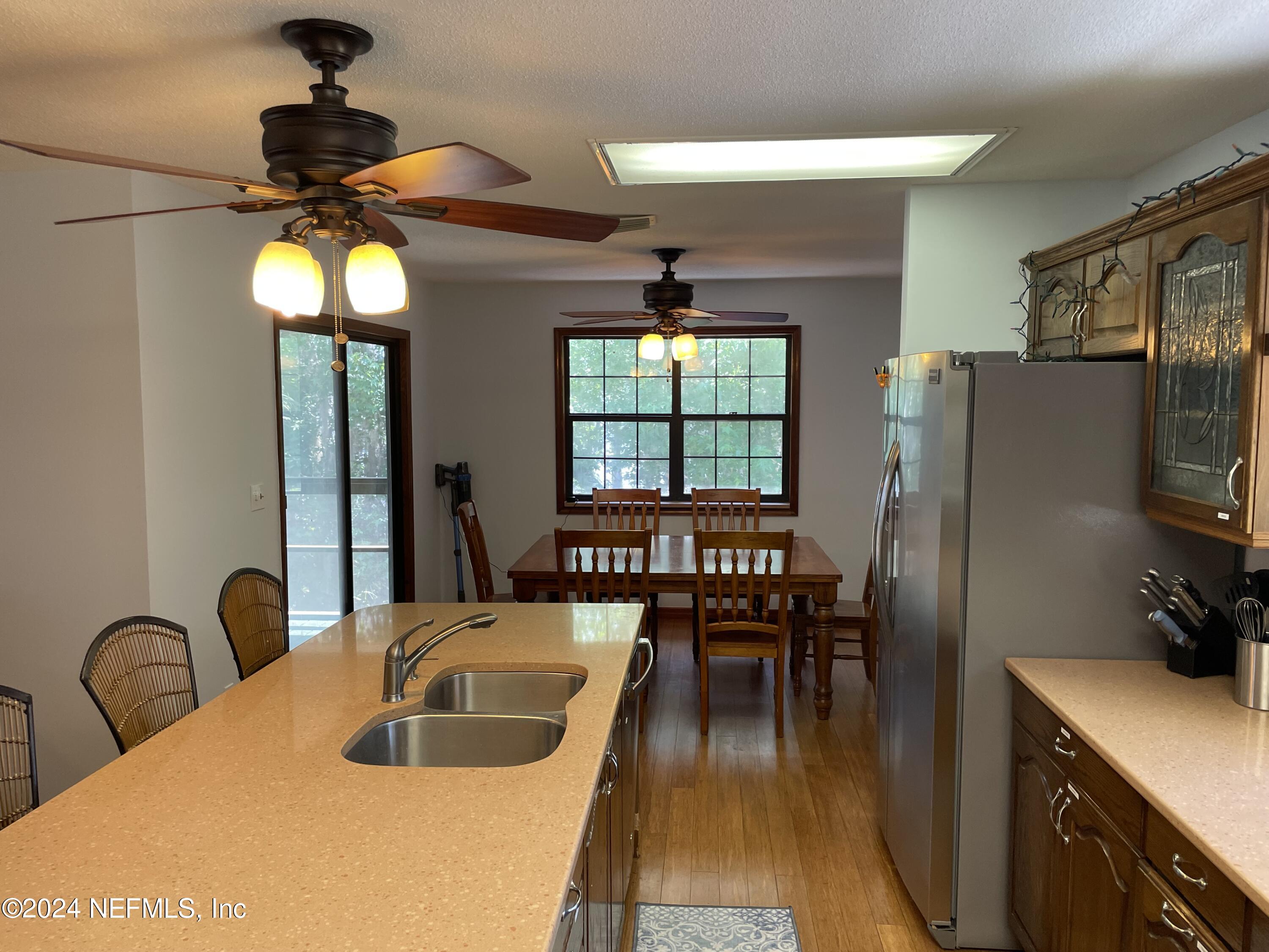 110 North Point Drive Georgetown, FL 32139 - Photo 10 of 28 a kitchen with a refrigerator a stove a dining table and chairs with wooden floor