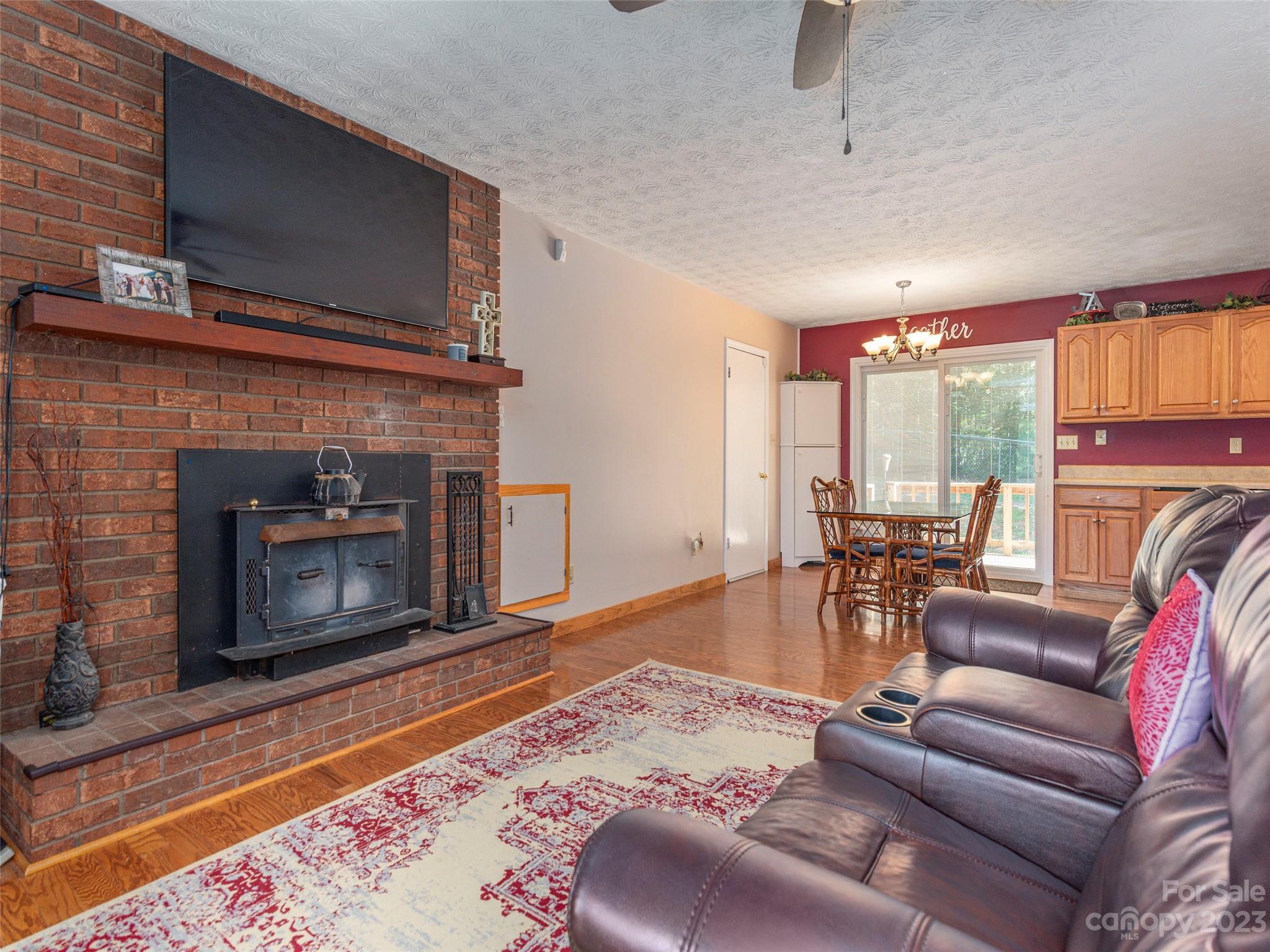 167 Paradise Circle Clyde, NC 28721 - Photo 5 of 18 a living room with furniture a flat screen tv and a fireplace