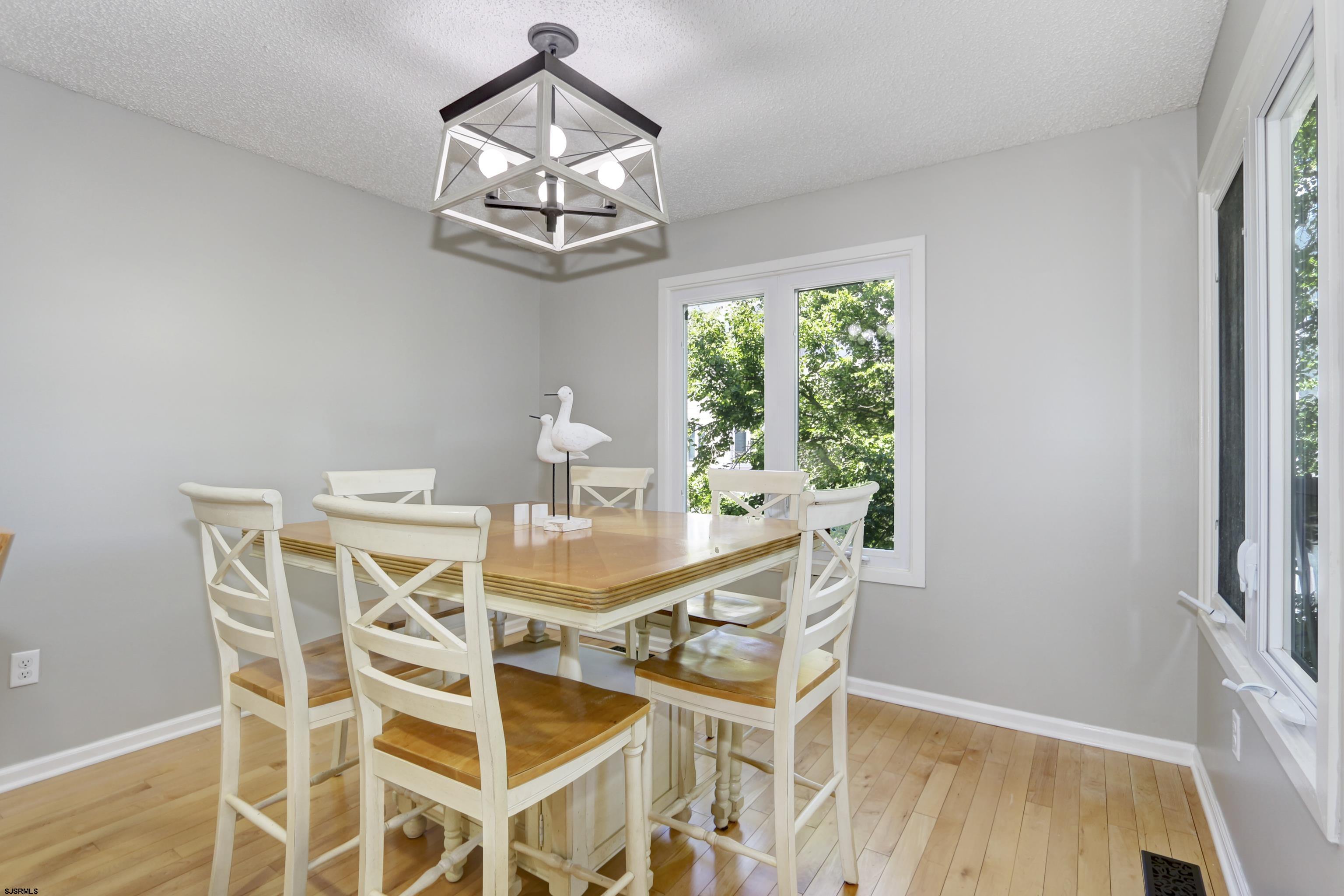 17 Coquille, Unit 17 Brigantine, NJ 08203 - Photo 15 of 33 a view of a dining room with furniture a chandelier and wooden floor