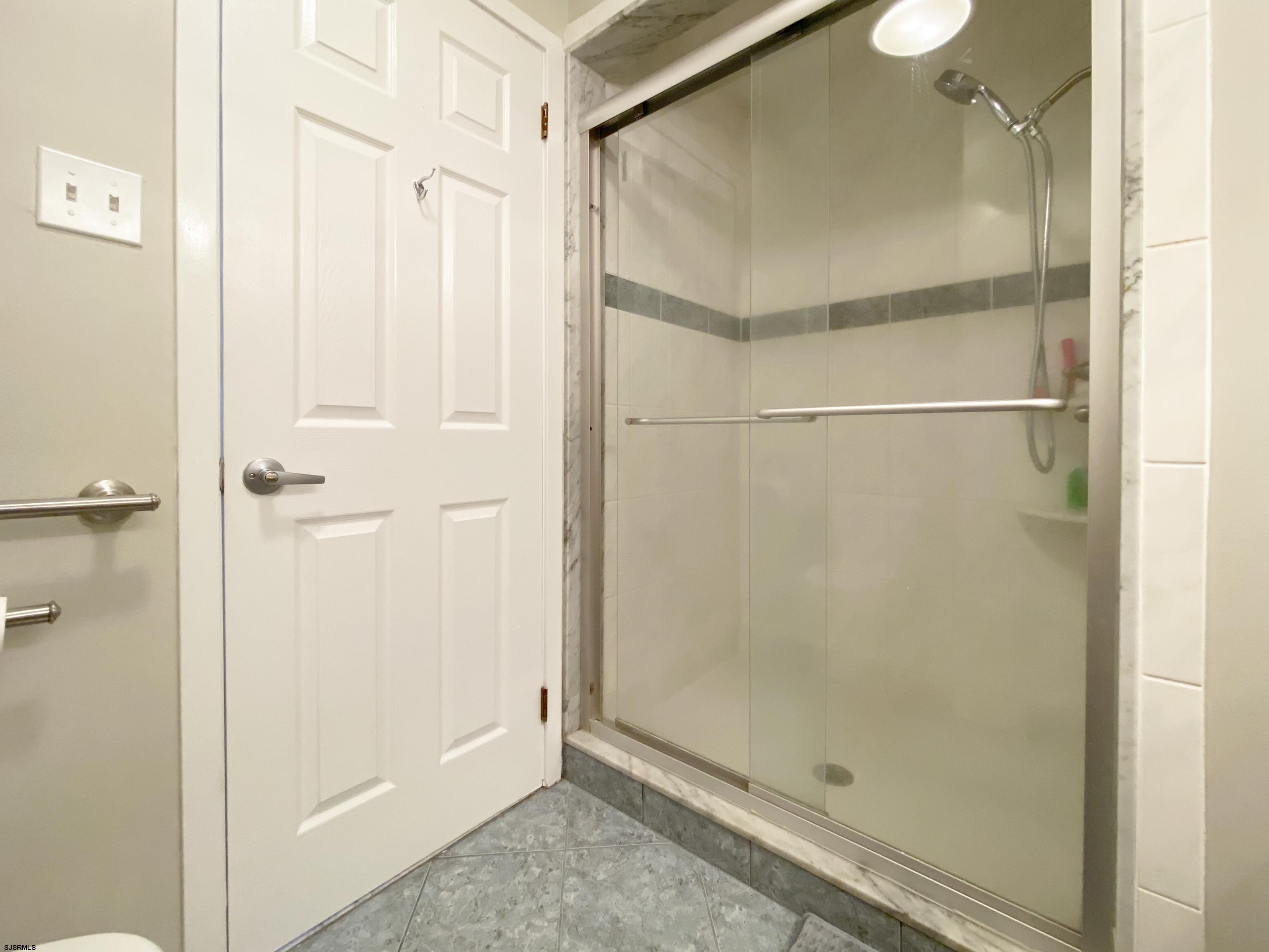17 Coquille, Unit 17 Brigantine, NJ 08203 - Photo 25 of 33 a bathroom with a glass shower door