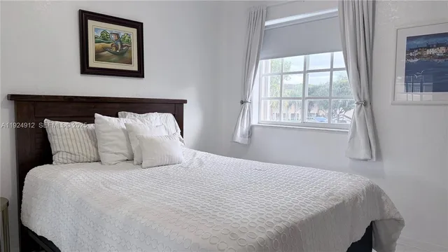 a large bed in a bedroom next to a window