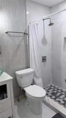 a white toilet sitting next to a shower curtain