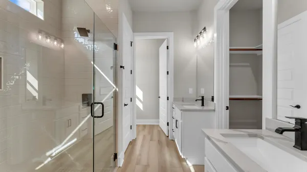 a bathroom with a double vanity sink a mirror and shower