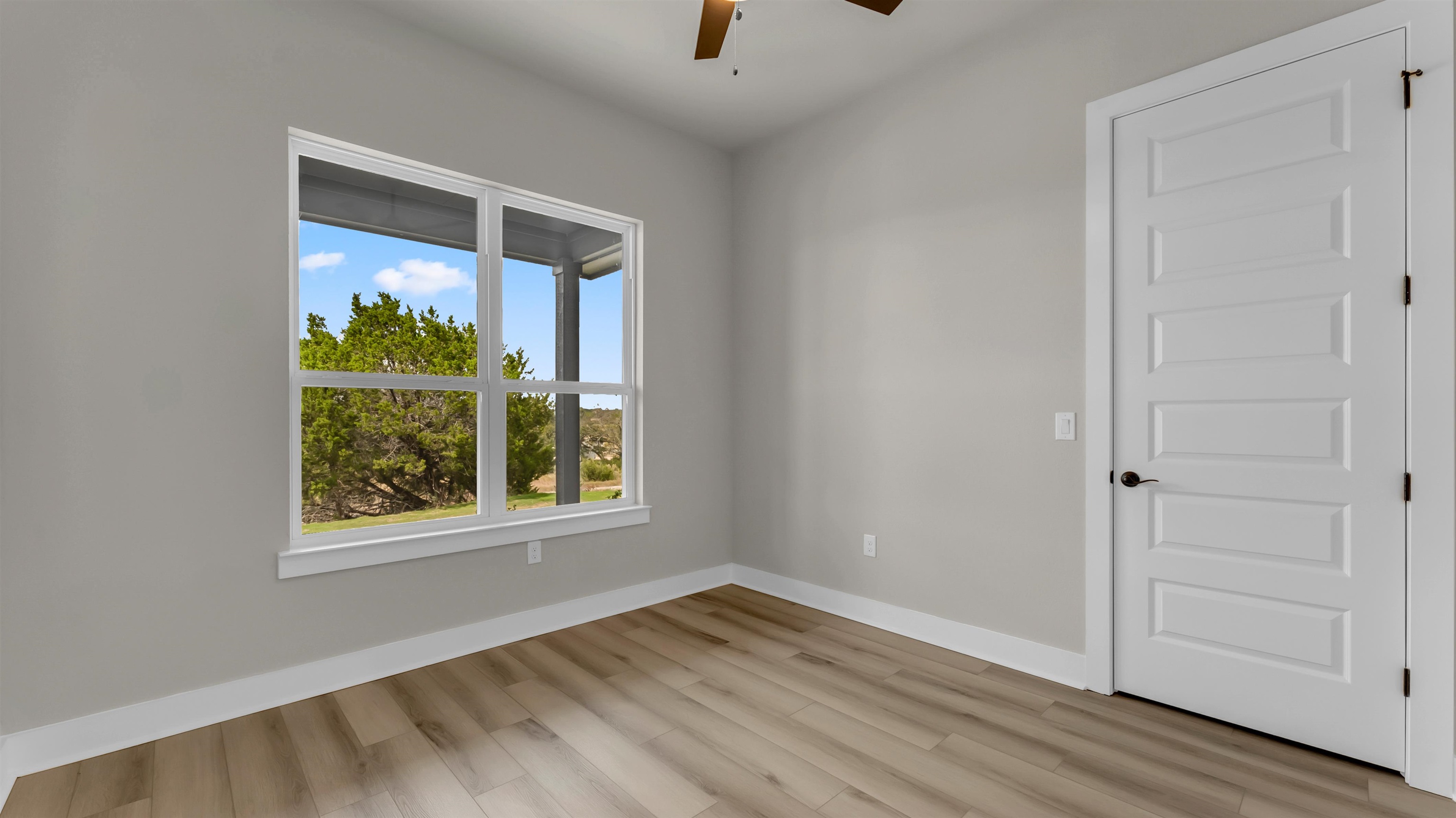 119 Garner Rnch Road Bertram, TX 78605 - Photo 17 of 25 an empty room with wooden floor and windows