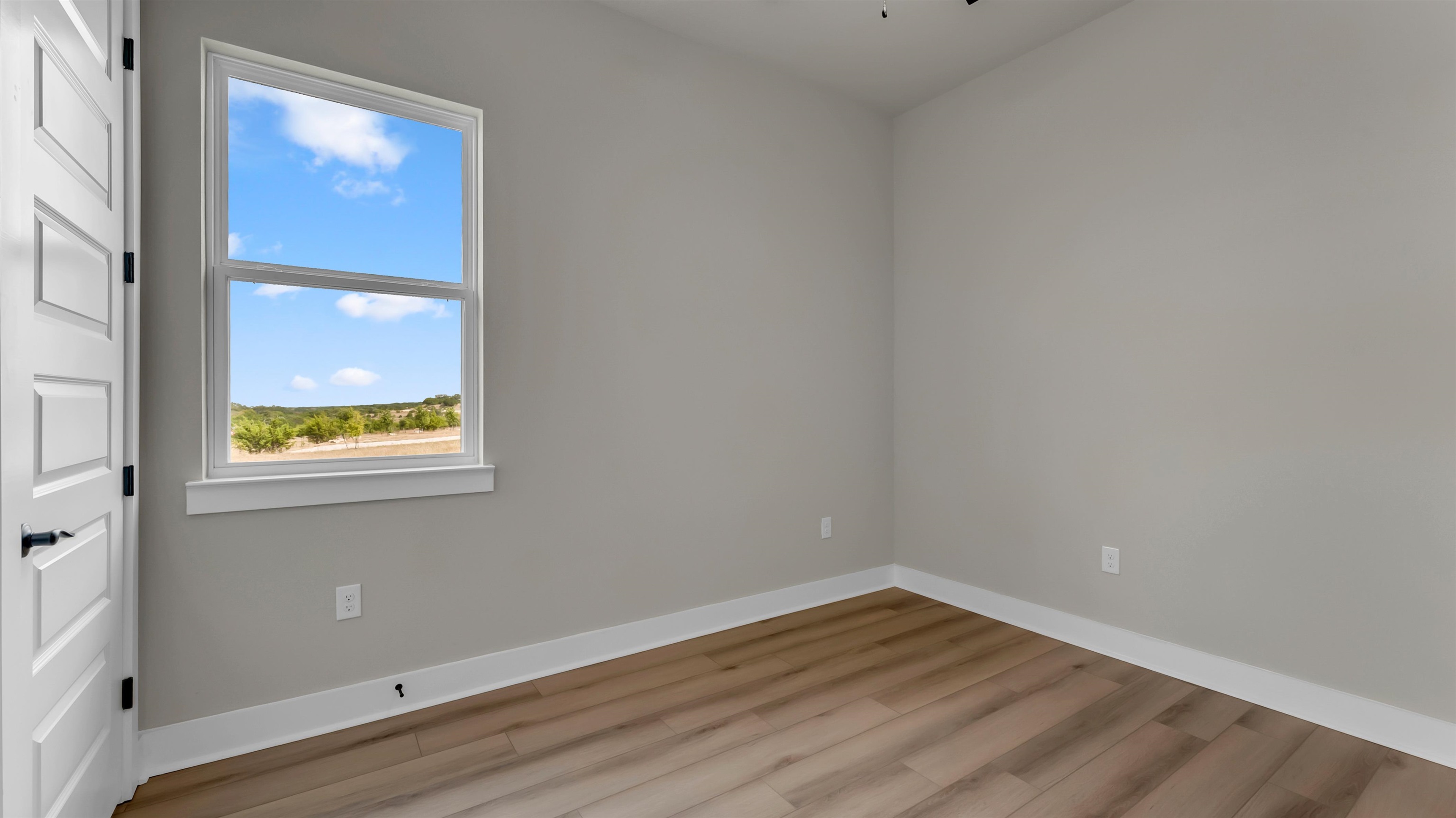 119 Garner Rnch Road Bertram, TX 78605 - Photo 18 of 25 a view of an empty room with wooden floor and a window