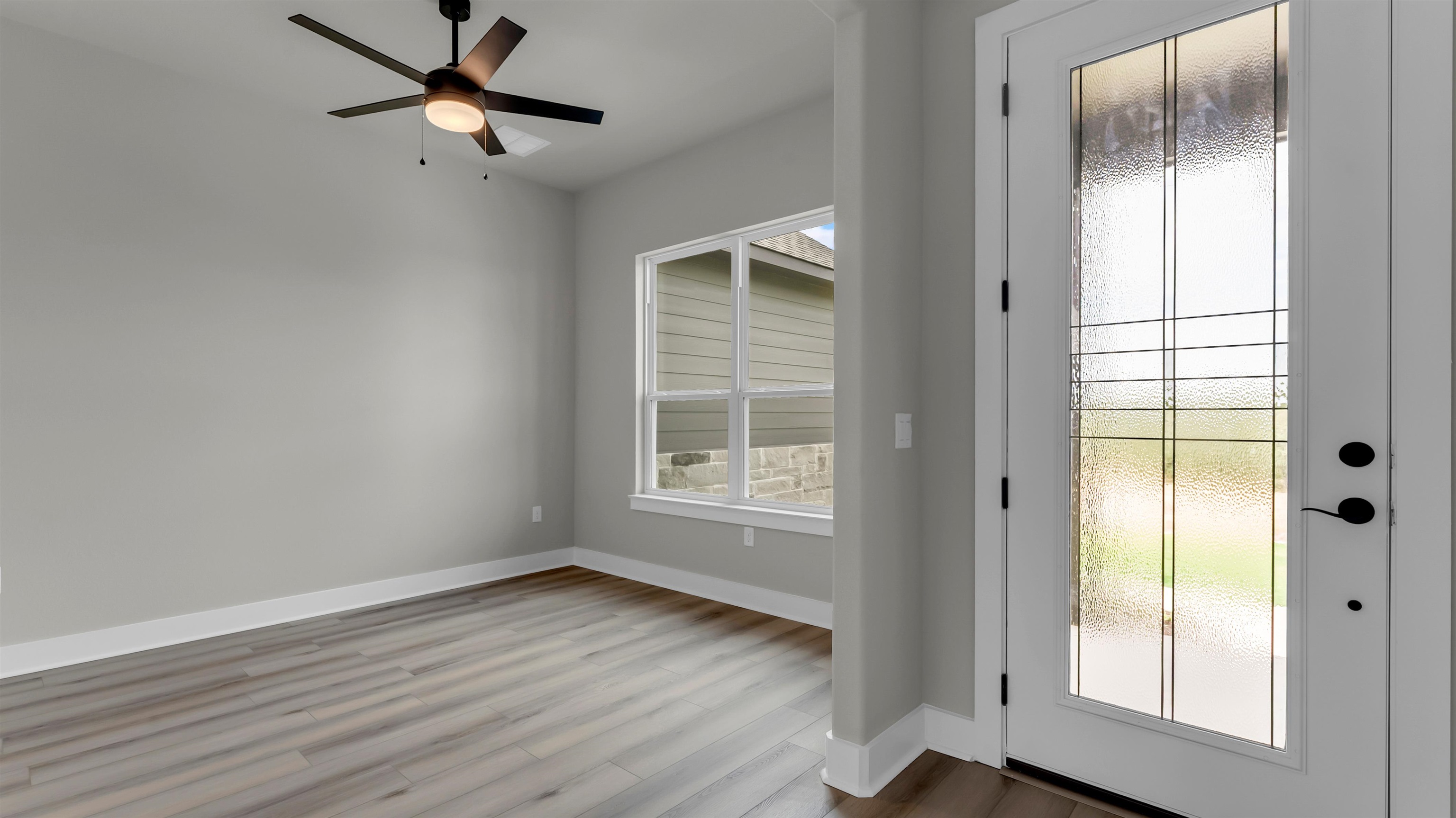 119 Garner Rnch Road Bertram, TX 78605 - Photo 4 of 25 an empty room with wooden floor fan and windows