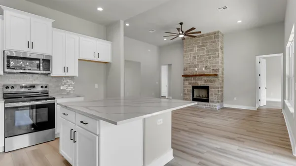 a kitchen with white cabinets and appliances