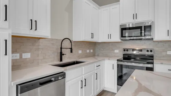 a kitchen with granite countertop a sink stove and refrigerator
