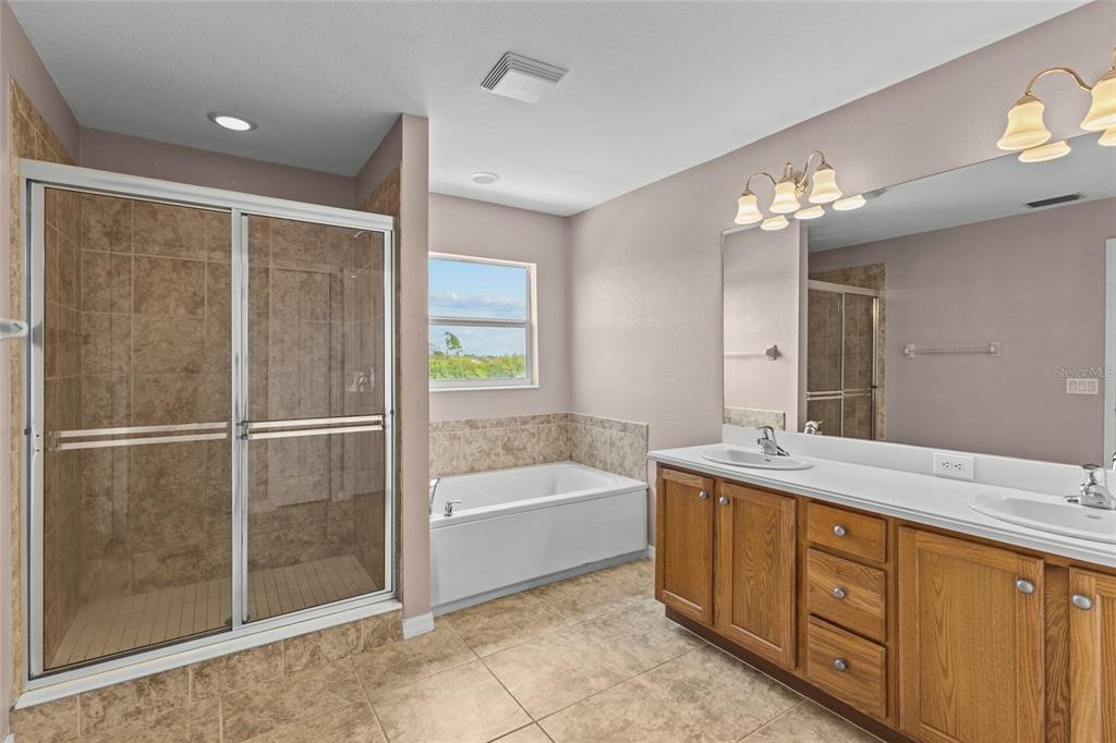 11754 Tempest Harbor Loop Venice, FL 34292 - Photo 24 of 56 a spacious bathroom with a granite countertop sink a toilet a mirror and shower