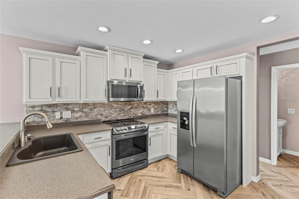 11754 Tempest Harbor Loop Venice, FL 34292 - Photo 7 of 56 a kitchen with a sink stove and refrigerator
