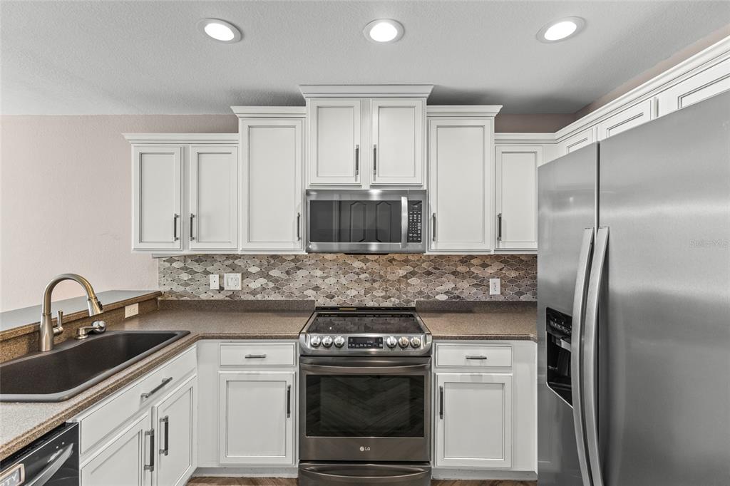 11754 Tempest Harbor Loop Venice, FL 34292 - Photo 8 of 56 a kitchen with stainless steel appliances granite countertop a sink stove and refrigerator
