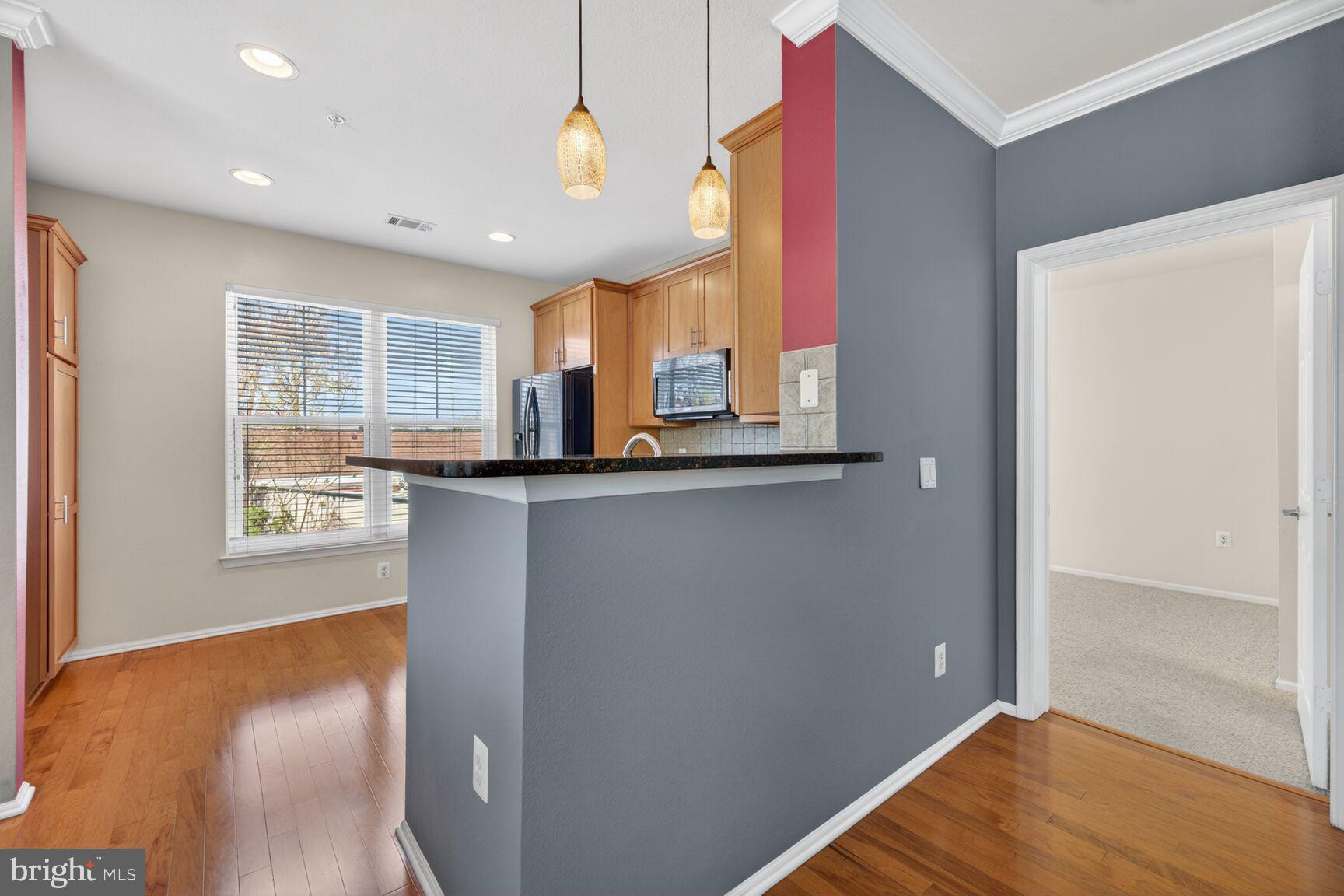 11800 Old Georgetown Road, Unit 1541 North Bethesda, MD 20852 - Photo 4 of 34 a view of a kitchen with kitchen island a sink wooden floor and a window