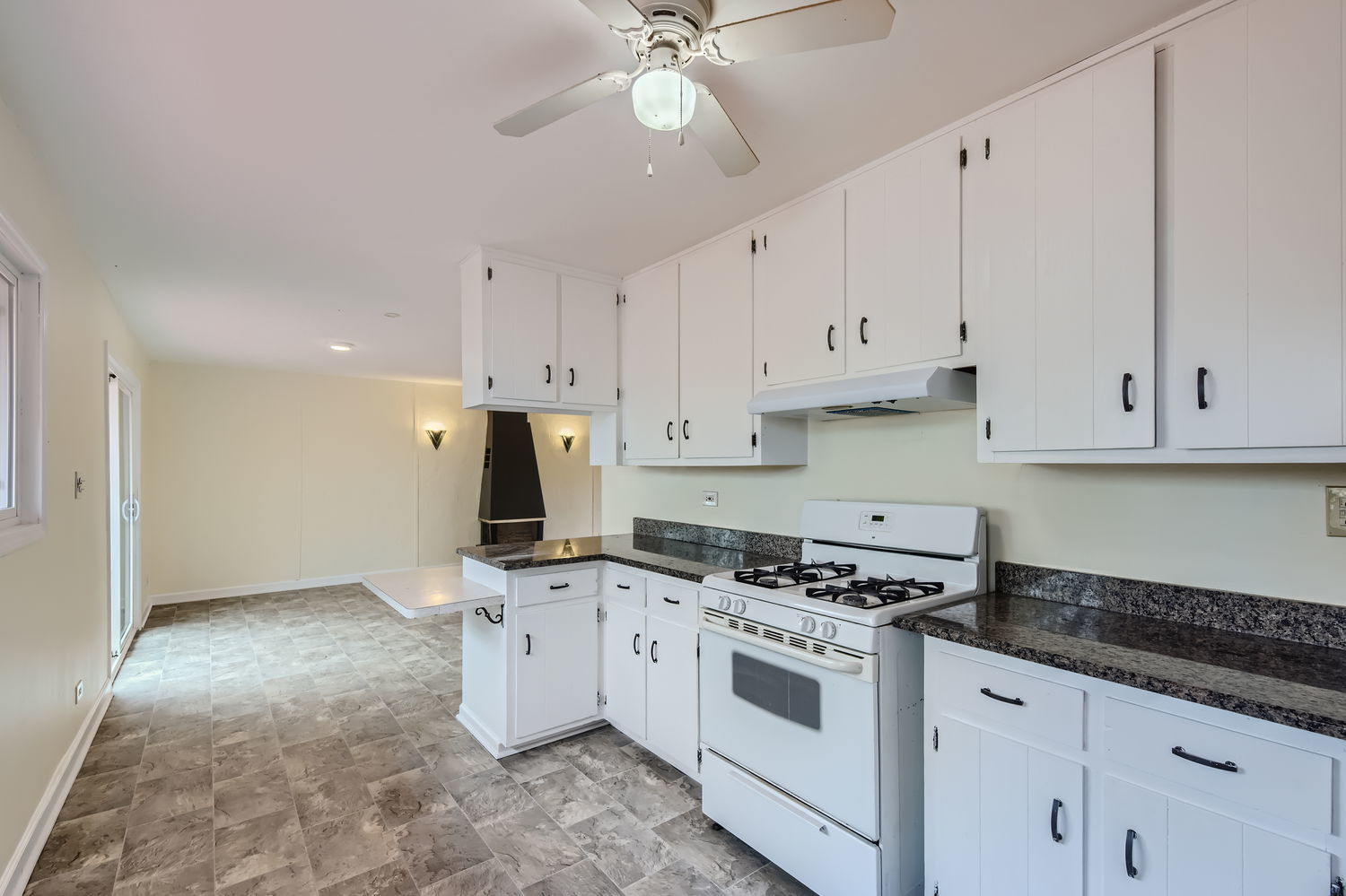303 Audubon Road Streamwood, IL 60107 - Photo 7 of 30 a kitchen with granite countertop a stove a sink and white cabinets