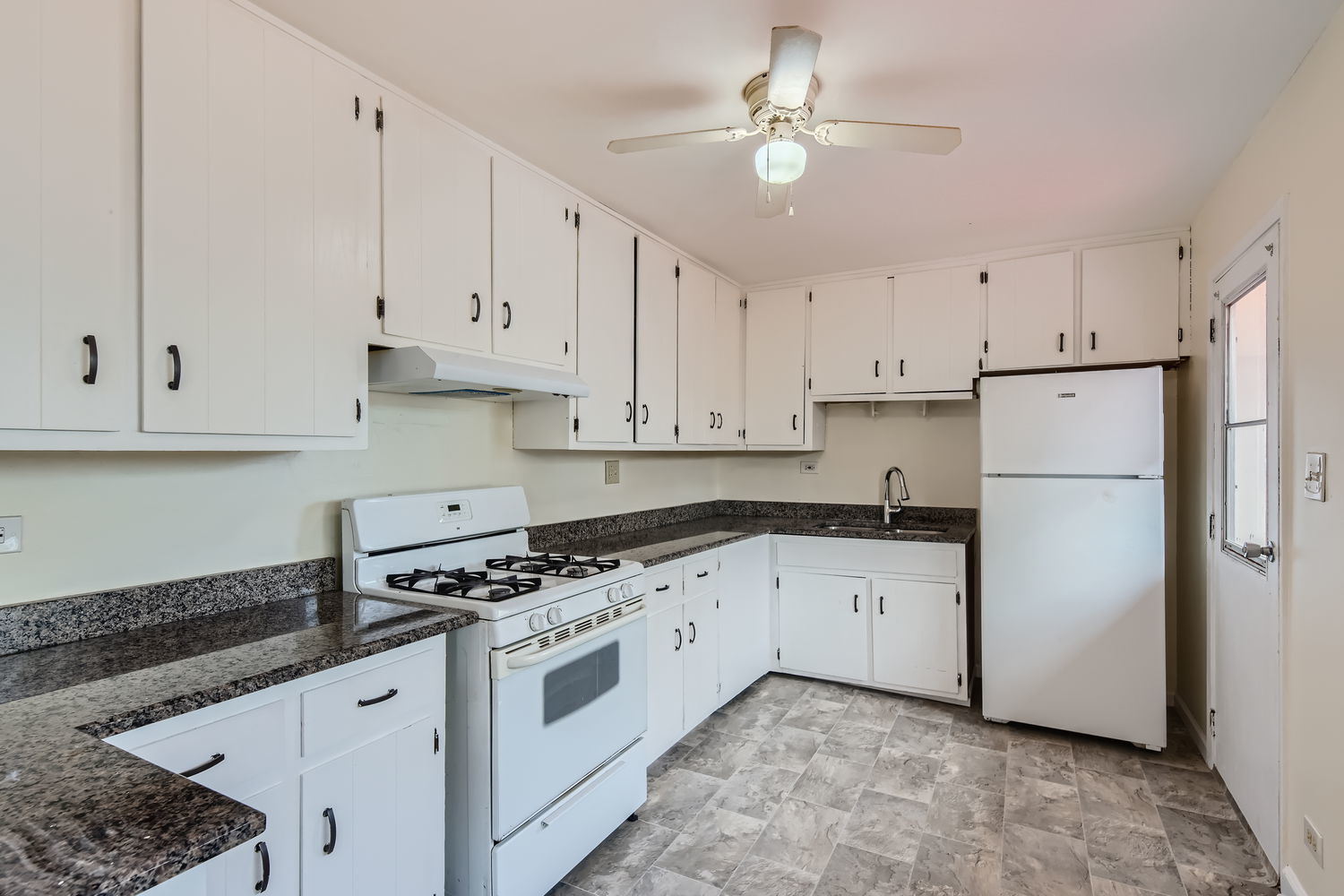 303 Audubon Road Streamwood, IL 60107 - Photo 8 of 30 a kitchen with granite countertop white cabinets white appliances and sink