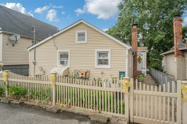 a view of a house with a small yard and wooden fence