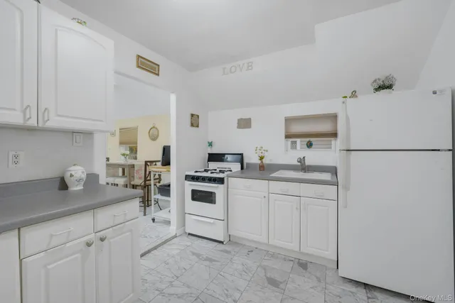 a kitchen with a sink stove and white cabinets