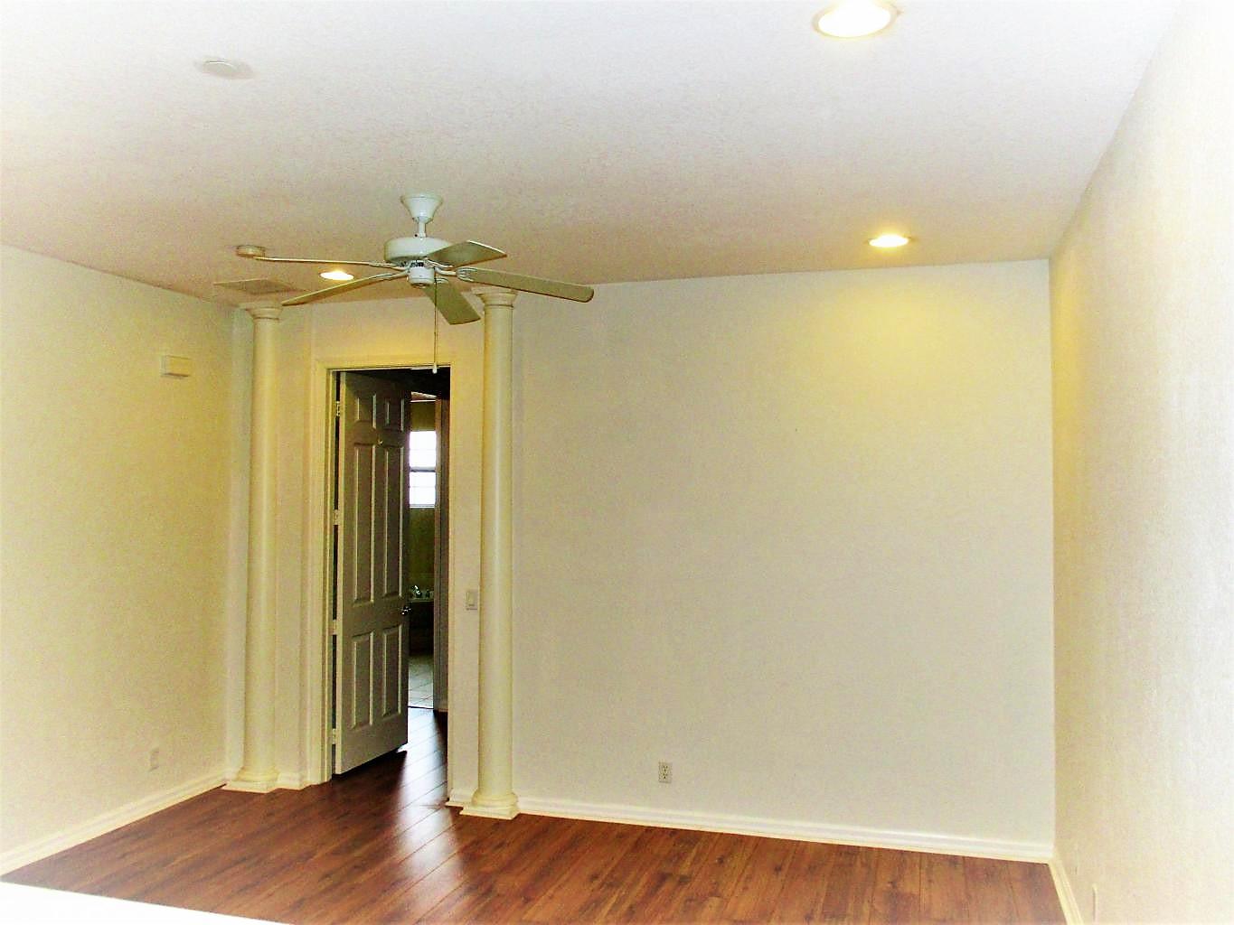 116 Lancaster Road Boynton Beach, FL 33426 - Photo 13 of 28 an empty room with wooden floor and a ceiling fan