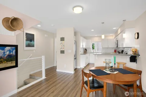a kitchen with stainless steel appliances granite countertop a sink dishwasher a stove and a refrigerator with wooden floor
