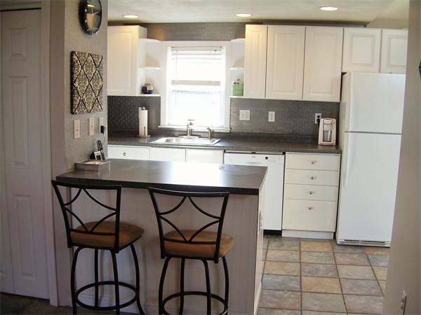 1 Anthony Road Peabody, MA 01960 - Photo 7 of 29 a kitchen with stainless steel appliances a stove a refrigerator a sink and white cabinets with wooden floor
