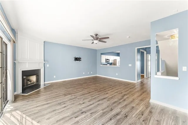 a view of an empty room with a fireplace and a window