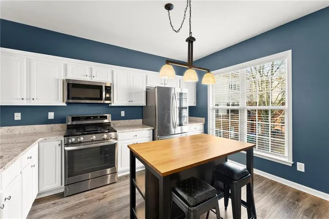a kitchen with a stove a refrigerator and a dining table