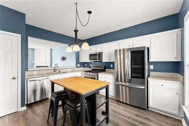 a kitchen with stainless steel appliances a stove a refrigerator and a kitchen island