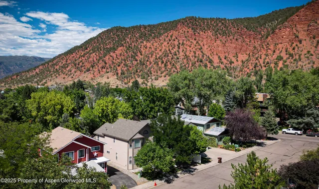 an aerial view of house with yard and mountain view in back