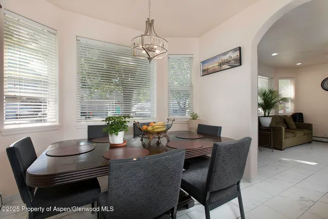 a dining room with furniture a large window and a chandelier